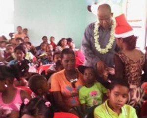 PPP General Secretary Clement Rohee distributing gifts to the Children with assistance from local comrades.