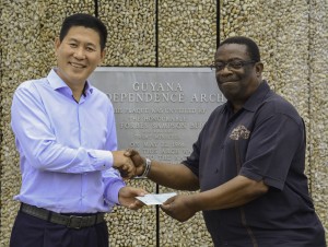 Managing Director of Baishanlin, Chu Hongbo hands cheque over to Chief Coordinator, Larry London 