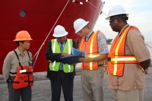 Mr. Dave Tuls, ESSO's Venture Manager, briefs Minister of Governance, Mr. Raphael Trotman; while Mr Patrick Lee [first, left) and Newell Dennison, Acting Commissioner, Guyana Geology and Mines Commission look on.